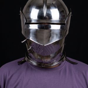 15th century armet helmet front view worn on fighter showing open visor with horizontal sight slit, rounded skull with raised medial ridge, and integrated articulated gorget lames, steel combat helmet for SCA and Buhurt